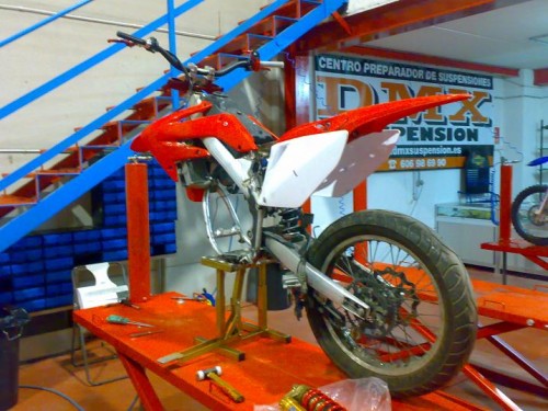 la moto en el centro preparador con el amortiguador anterior y con el ohlins listo para las pruebas antes tenia el muelle rojo